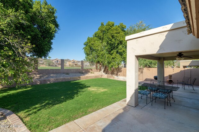 view of yard featuring ceiling fan and a patio