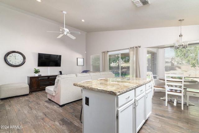 kitchen featuring hanging light fixtures, dark hardwood / wood-style floors, a center island, and white cabinetry