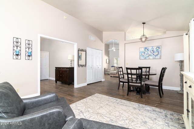 living room featuring dark wood-type flooring, vaulted ceiling, and ceiling fan