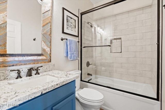 full bathroom featuring bath / shower combo with glass door, vanity, and toilet