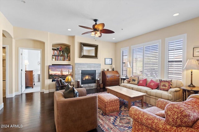 living room featuring dark wood-type flooring and ceiling fan