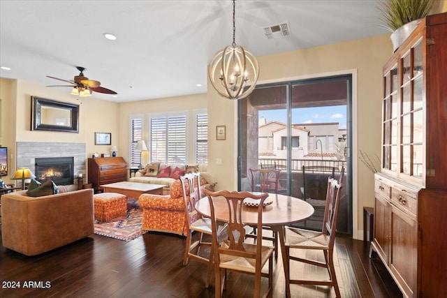 dining room featuring ceiling fan with notable chandelier and dark hardwood / wood-style flooring