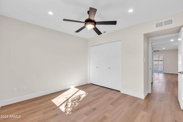 unfurnished bedroom featuring ceiling fan, a closet, and light hardwood / wood-style flooring