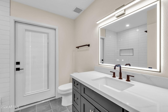 bathroom with tile patterned flooring, a shower, vanity, and toilet