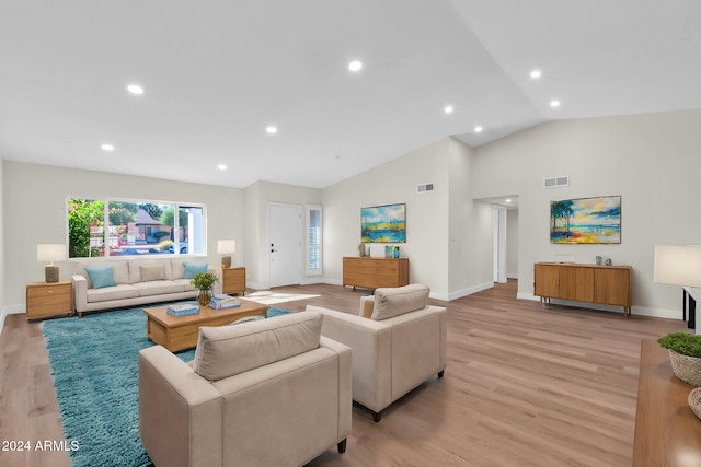 living room featuring light wood-type flooring and vaulted ceiling