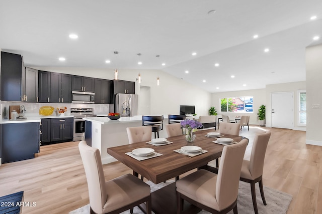 dining room with light hardwood / wood-style floors and vaulted ceiling