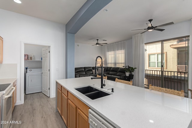 kitchen featuring sink, light hardwood / wood-style flooring, dishwasher, washer / dryer, and white range with electric cooktop