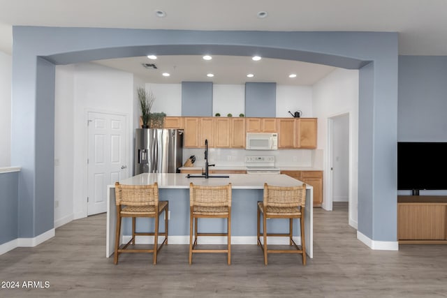 kitchen featuring a kitchen bar, stainless steel fridge, stove, and a spacious island