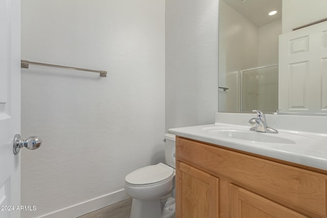 bathroom with vanity, toilet, and an enclosed shower