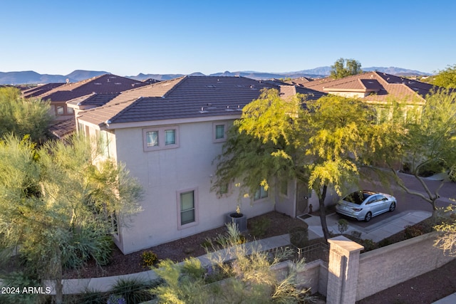 view of side of home with a mountain view and central AC