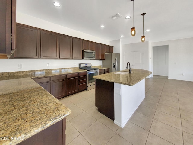 kitchen with appliances with stainless steel finishes, stone countertops, sink, and decorative light fixtures