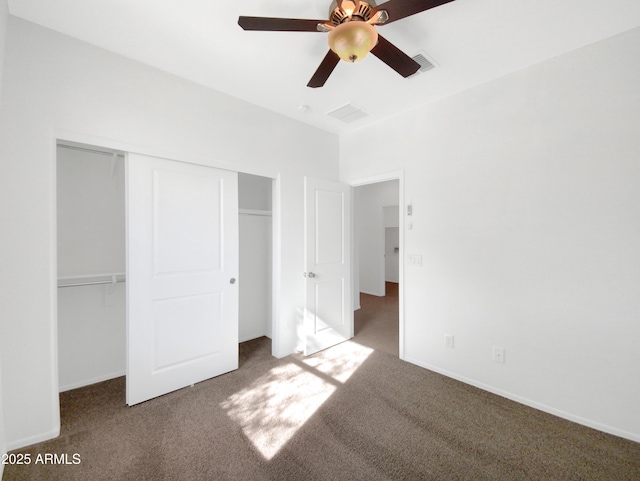 unfurnished bedroom with ceiling fan, a closet, and dark colored carpet