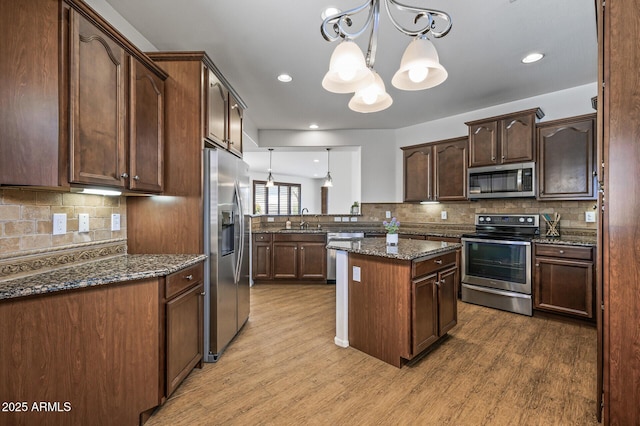 301 S 225th Ave, Buckeye, AZ 85326 - kitchen with stainless steel appliances, a sink, an inviting chandelier, and wood finished floors