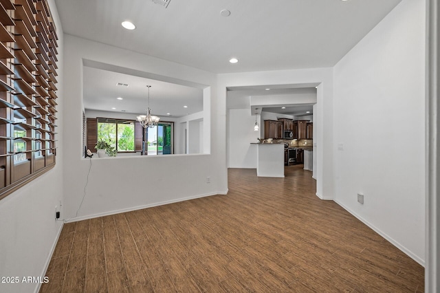 301 S 225th Ave, Buckeye, AZ 85326 - unfurnished living room featuring recessed lighting, a notable chandelier, dark wood-style floors, and baseboards