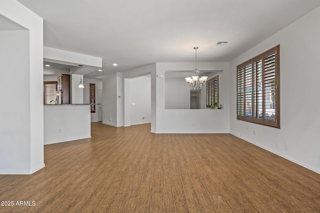 301 S 225th Ave, Buckeye, AZ 85326 - unfurnished living room with an inviting chandelier, visible vents, recessed lighting, wood finished floors, and baseboards
