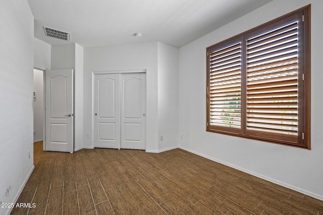 301 S 225th Ave, Buckeye, AZ 85326 - unfurnished bedroom with visible vents, a closet, baseboards, and dark wood-style floors