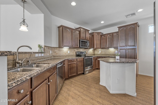 301 S 225th Ave, Buckeye, AZ 85326 - kitchen with dark stone countertops, visible vents, a sink, appliances with stainless steel finishes, and decorative backsplash