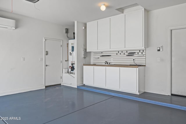 301 S 225th Ave, Buckeye, AZ 85326 - garage with electric water heater, an AC wall unit, baseboards, and a sink