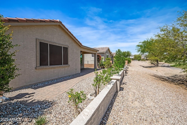 301 S 225th Ave, Buckeye, AZ 85326 - view of side of home featuring a garden, a tile roof, and stucco siding
