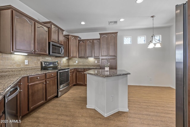 301 S 225th Ave, Buckeye, AZ 85326 - kitchen with tasteful backsplash, visible vents, appliances with stainless steel finishes, and wood finished floors