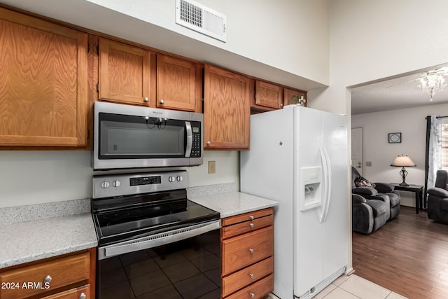 kitchen featuring light stone countertops, light hardwood / wood-style floors, and appliances with stainless steel finishes