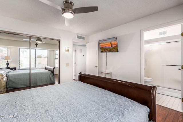 bedroom with a textured ceiling, a closet, ceiling fan, and connected bathroom