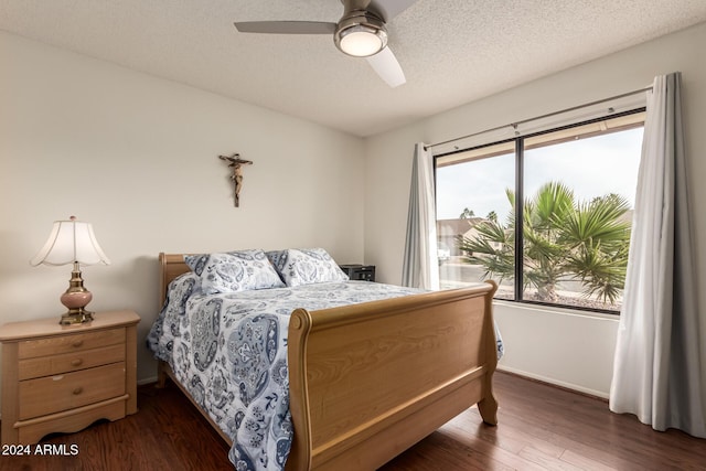 bedroom with ceiling fan, dark hardwood / wood-style floors, and a textured ceiling