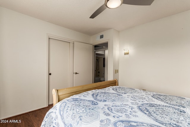 bedroom featuring dark hardwood / wood-style flooring, ceiling fan, and a closet