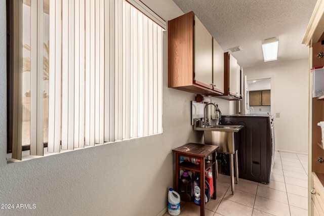 kitchen featuring a textured ceiling, light tile patterned flooring, and sink