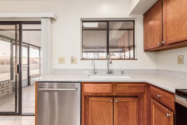 kitchen with light stone countertops, sink, light tile patterned flooring, and stainless steel appliances