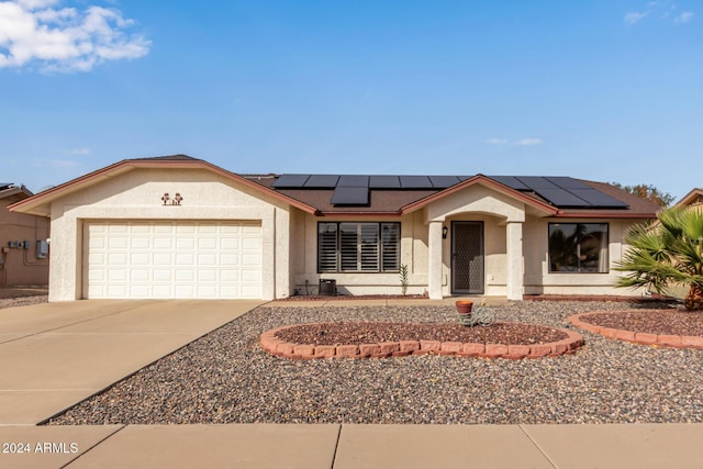 ranch-style home with solar panels and a garage