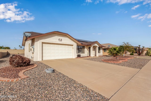 ranch-style house featuring solar panels and a garage