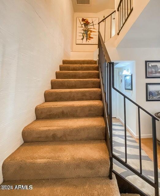 staircase with hardwood / wood-style flooring