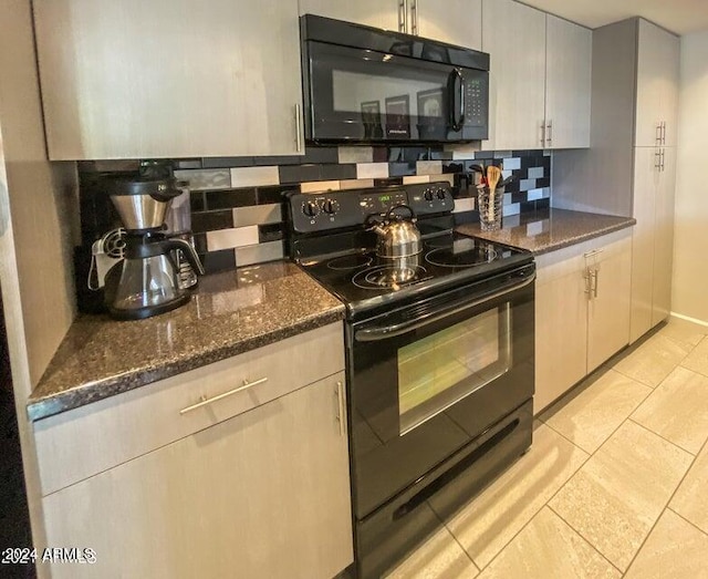 kitchen featuring light tile patterned flooring, dark stone countertops, tasteful backsplash, and black appliances