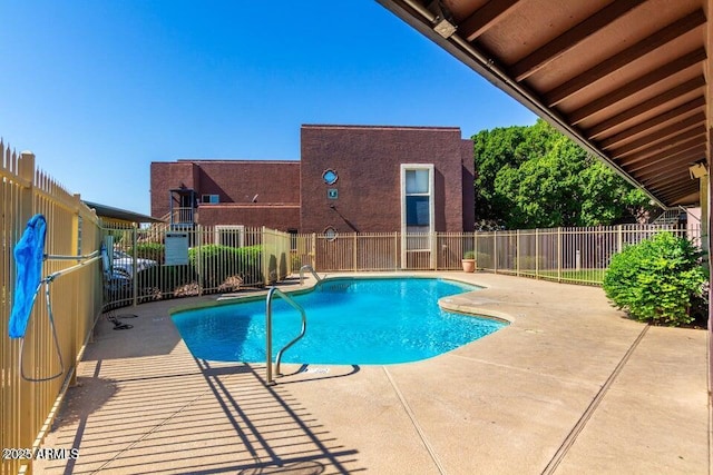 view of swimming pool with fence and a patio