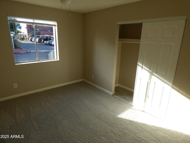 unfurnished bedroom featuring carpet, a closet, and baseboards