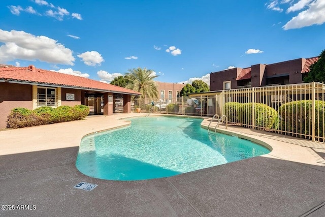 community pool featuring fence and a patio area