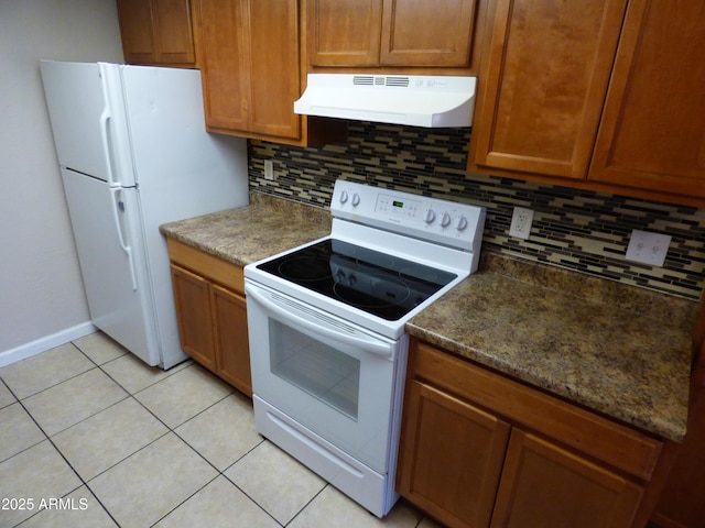 kitchen featuring under cabinet range hood, white appliances, backsplash, and brown cabinetry
