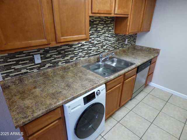 kitchen featuring washer / clothes dryer, stainless steel dishwasher, a sink, decorative backsplash, and light tile patterned flooring
