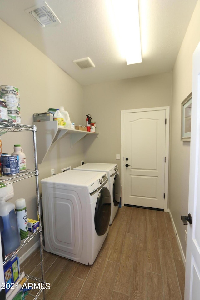 laundry room featuring washer and dryer and wood-type flooring