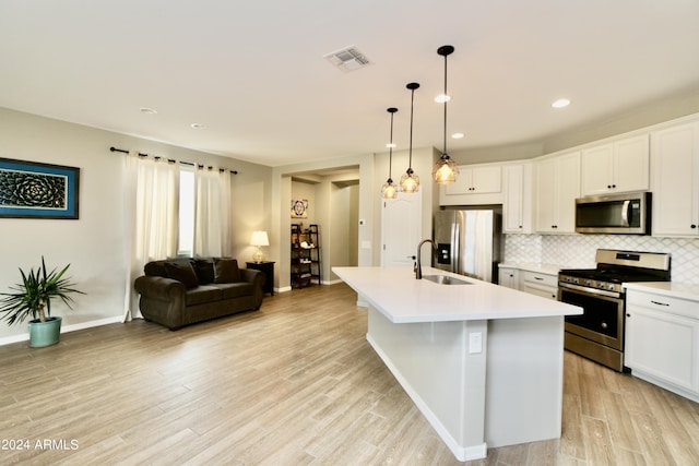 kitchen featuring stainless steel appliances, a kitchen island with sink, white cabinets, and pendant lighting