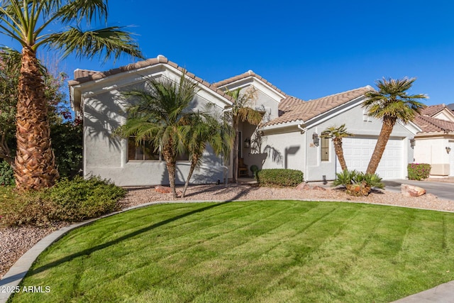 mediterranean / spanish home featuring a front yard and a garage