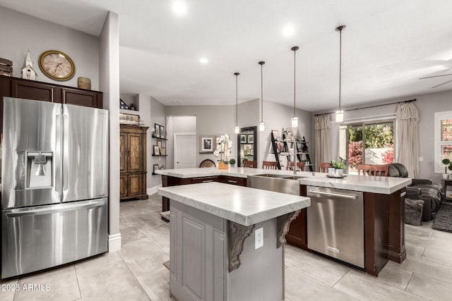 kitchen with kitchen peninsula, stainless steel appliances, dark brown cabinets, pendant lighting, and a center island