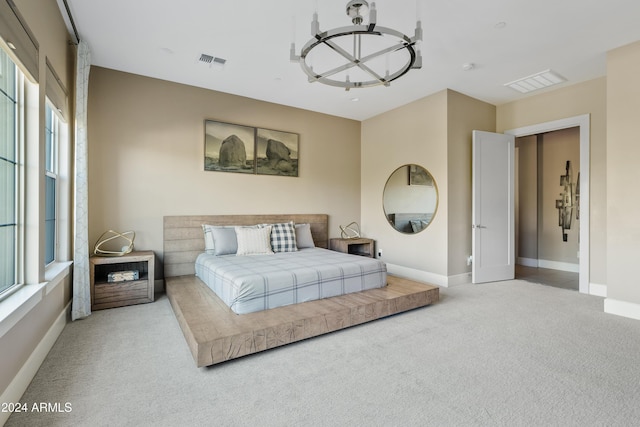 carpeted bedroom featuring an inviting chandelier and multiple windows