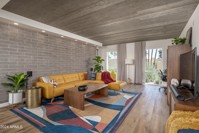 living room featuring brick wall and hardwood / wood-style floors