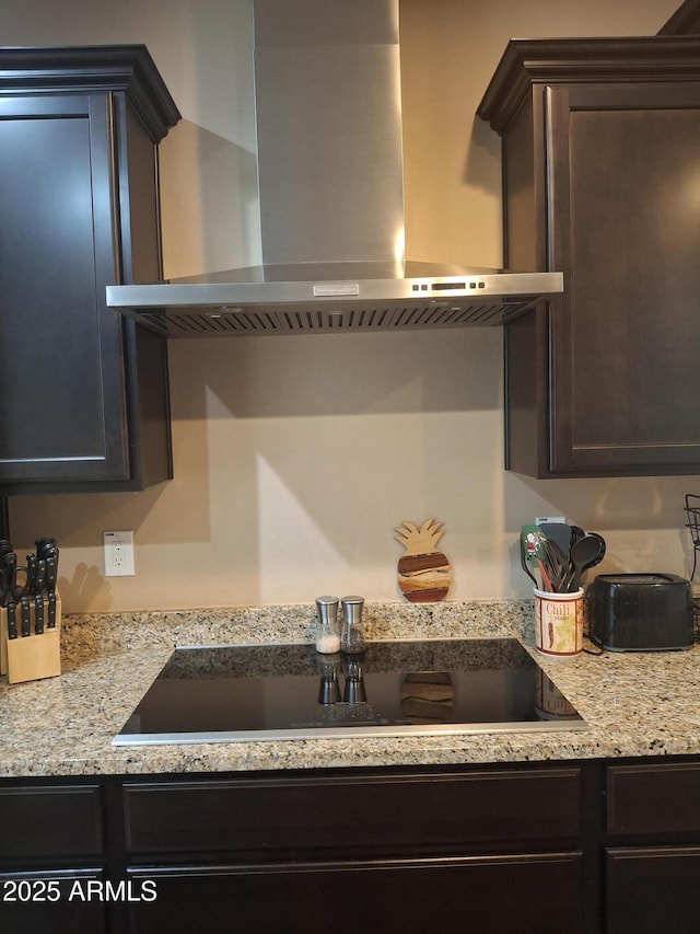 10773 W Prickly Pear Trl, Peoria, AZ 85383 - kitchen featuring wall chimney exhaust hood, black electric stovetop, dark brown cabinetry, and light stone countertops
