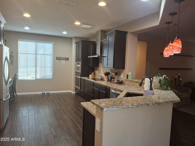 10773 W Prickly Pear Trl, Peoria, AZ 85383 - kitchen with stainless steel appliances, wall chimney exhaust hood, a peninsula, dark wood finished floors, and light stone counters