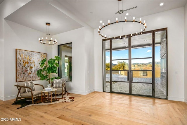 sitting room featuring a chandelier, baseboards, and hardwood / wood-style flooring