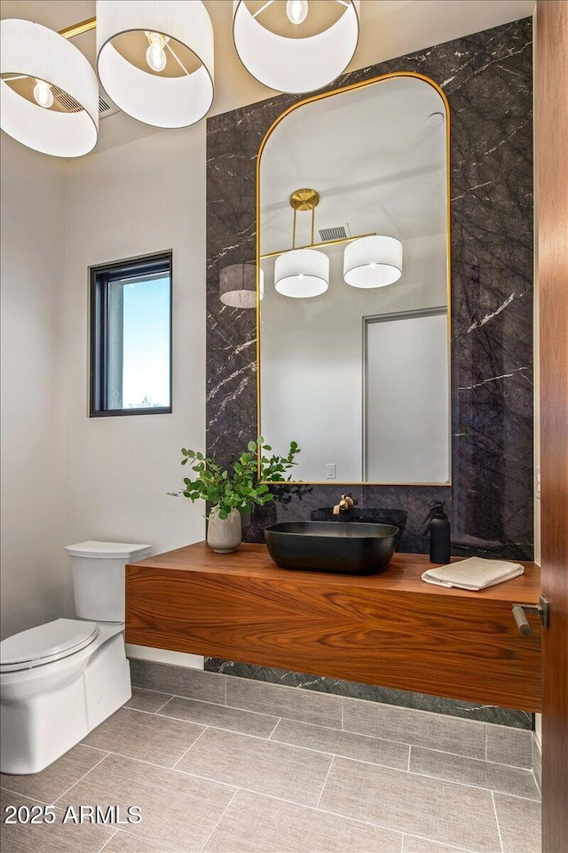 bathroom with vanity, toilet, and visible vents