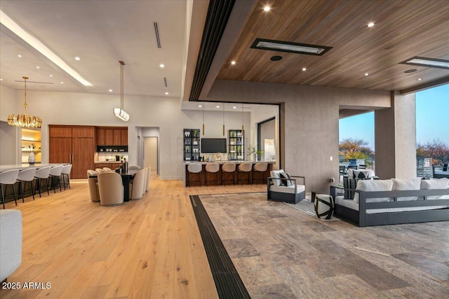 living area with recessed lighting, light wood-style flooring, and wood ceiling